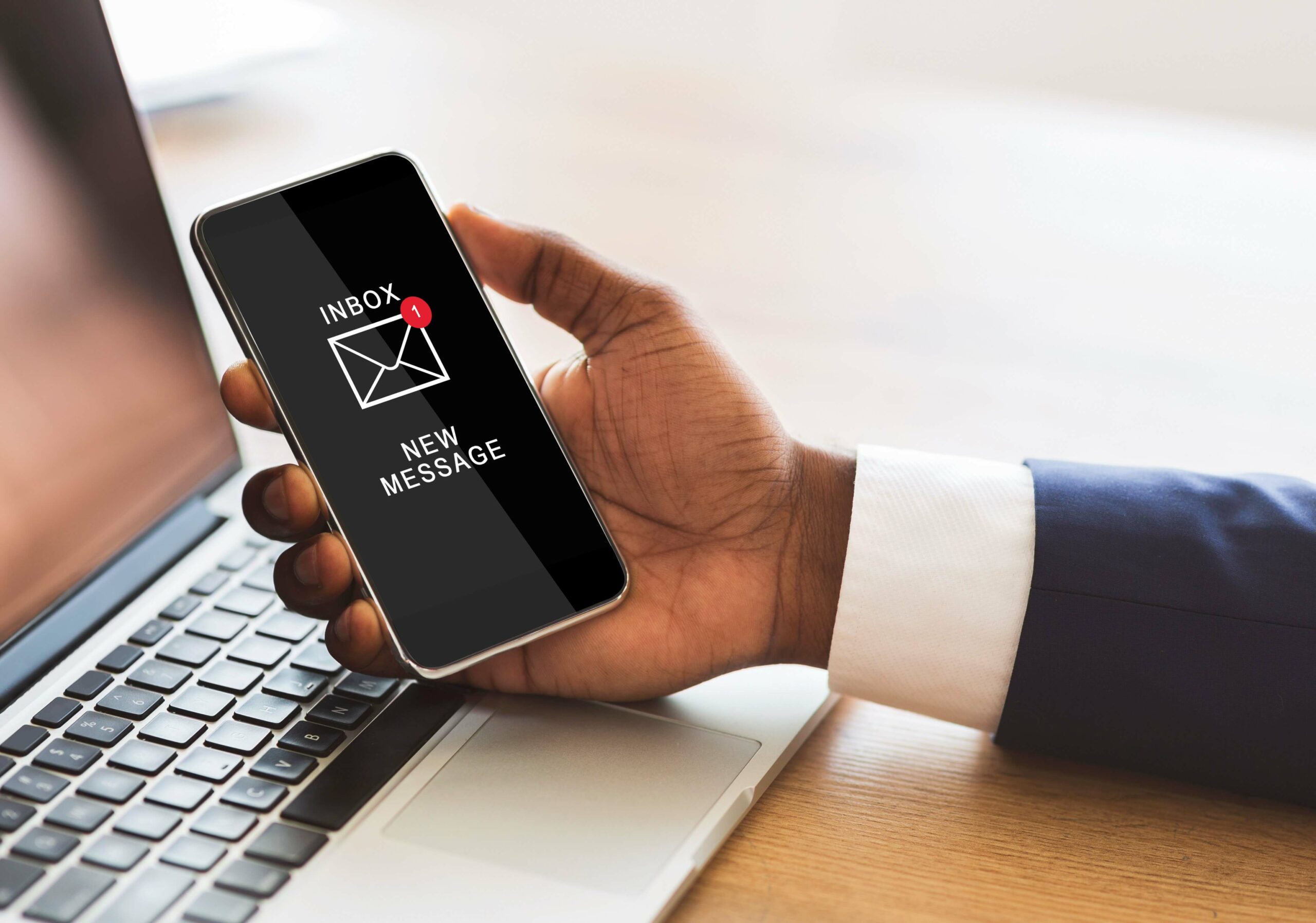 black-businessman-holding-smartphone-reading-e-mail